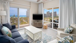 Un salon spacieux avec balcon, une télévision à écran plat et une vue sur le paysage urbain.