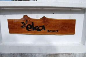 A wooden sign with the text "eka Resort" mounted on a white wall. - Eka Resorts (Sakleshpur)