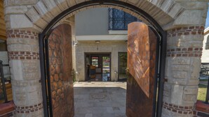 A stone archway leading to a building entrance with a tiled patio. - Dalyan Live Spa Hotel (Ortaca)