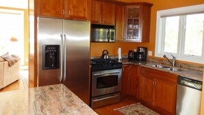A kitchen with wooden cabinets, stainless steel appliances, granite countertops, and a window providing natural light. - 2026-27 dates available! Mountain biking or hiking the Green Mtn, or ski Okemo! (Ludlow)