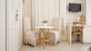A room with a white table, two chairs, a TV, and a small desk. - Domus Dejana (Gallipoli)