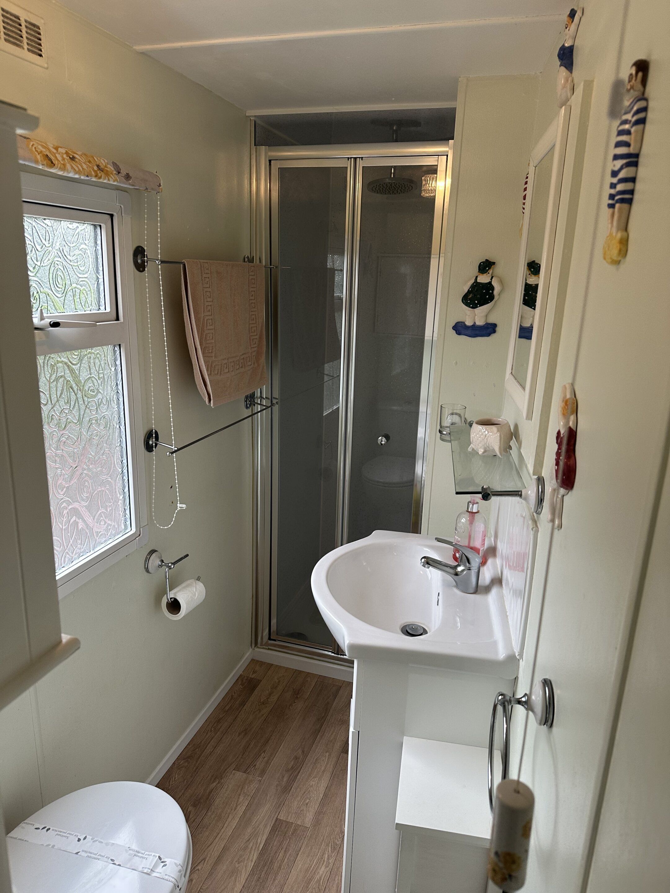 A compact bathroom with a shower, toilet, and sink.