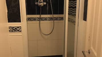 Ducha con puerta de vidrio, ducha de mano y grifo de mano.