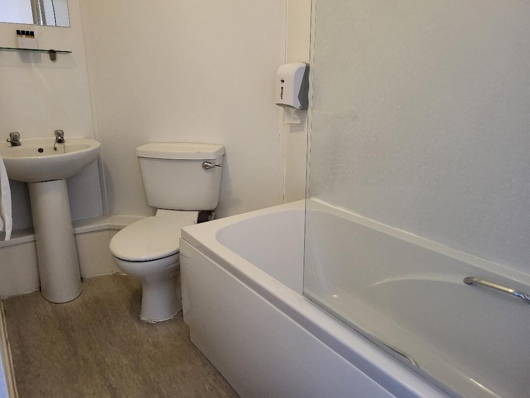 A bathroom with a toilet, sink, and bathtub.