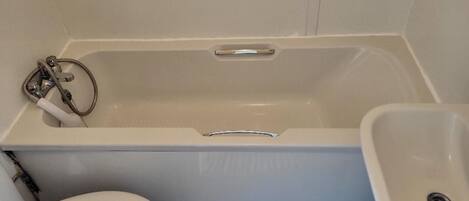 Un baño con bañera, inodoro y lavabo.
