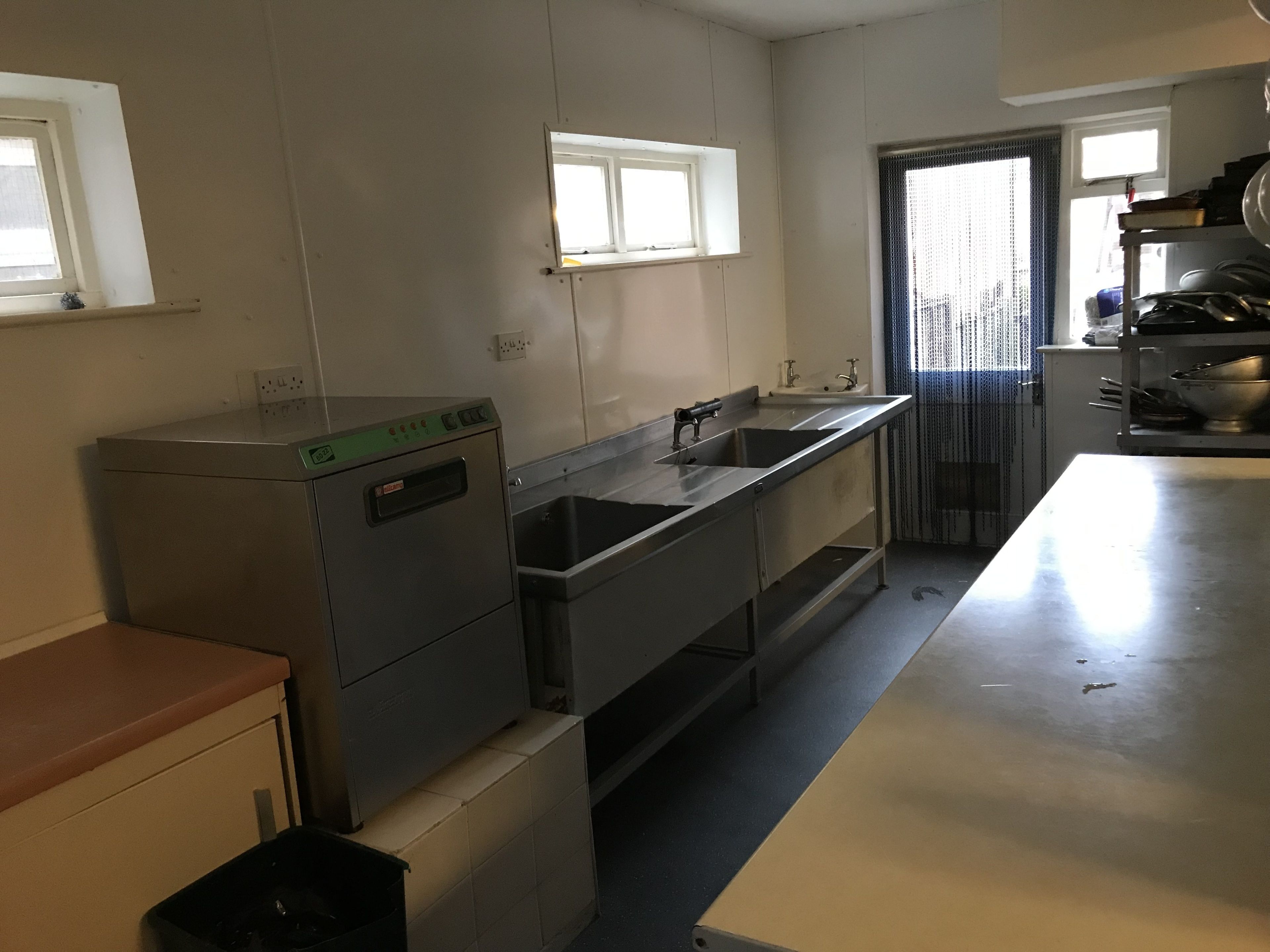 A kitchen with stainless steel appliances, a sink, and a window.