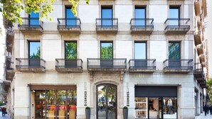 A hotel facade with multiple balconies, large glass windows, and a central entrance.