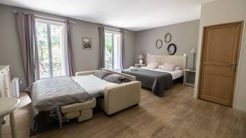 A bedroom with two beds, a bedside table, a chair, and a wardrobe.