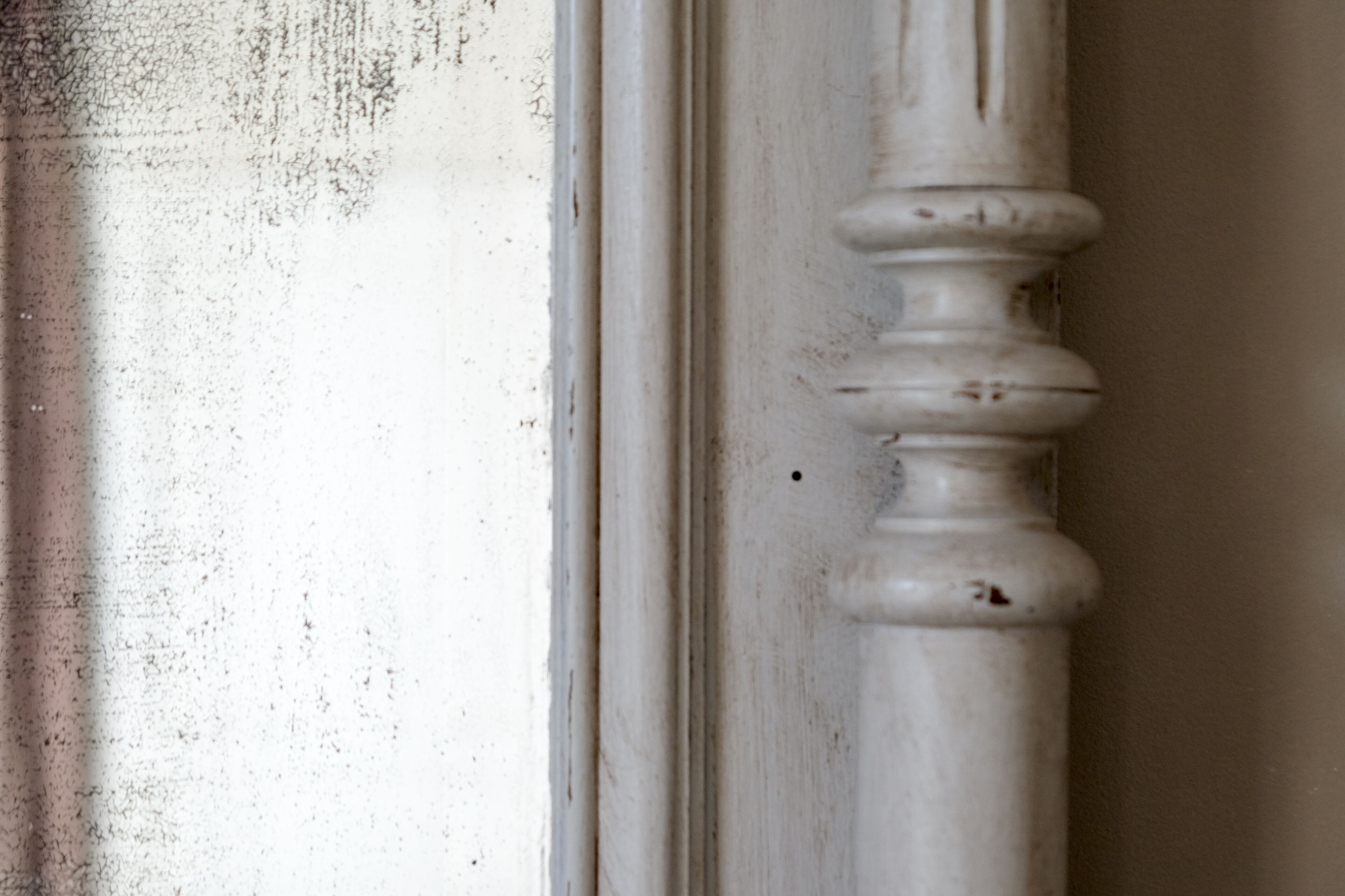 A close-up of a white, weathered column with a rounded capital.