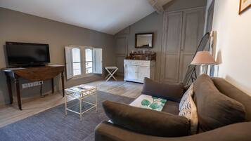 A living room with a television, a sofa, a coffee table, and a cabinet.