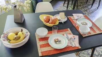 Een eettafel gedekt met borden, kommen en een vaas.
