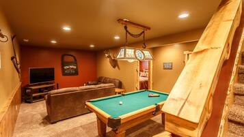 Relax in the GULCH TOP RETREAT lounge with a pool table, comfortable sofa, and TV.