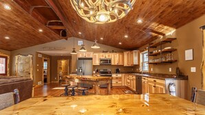 A spacious kitchen with a large island, wooden cabinets, and a rustic ceiling. - The Beautiful Whitetail Ridge-Luxury 5BR Cabin, Just minutes from downtown (Wisconsin Dells)
