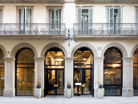 A hotel facade with three arched entrances, each with a sign reading "HOTEL DE ESPAÑA".