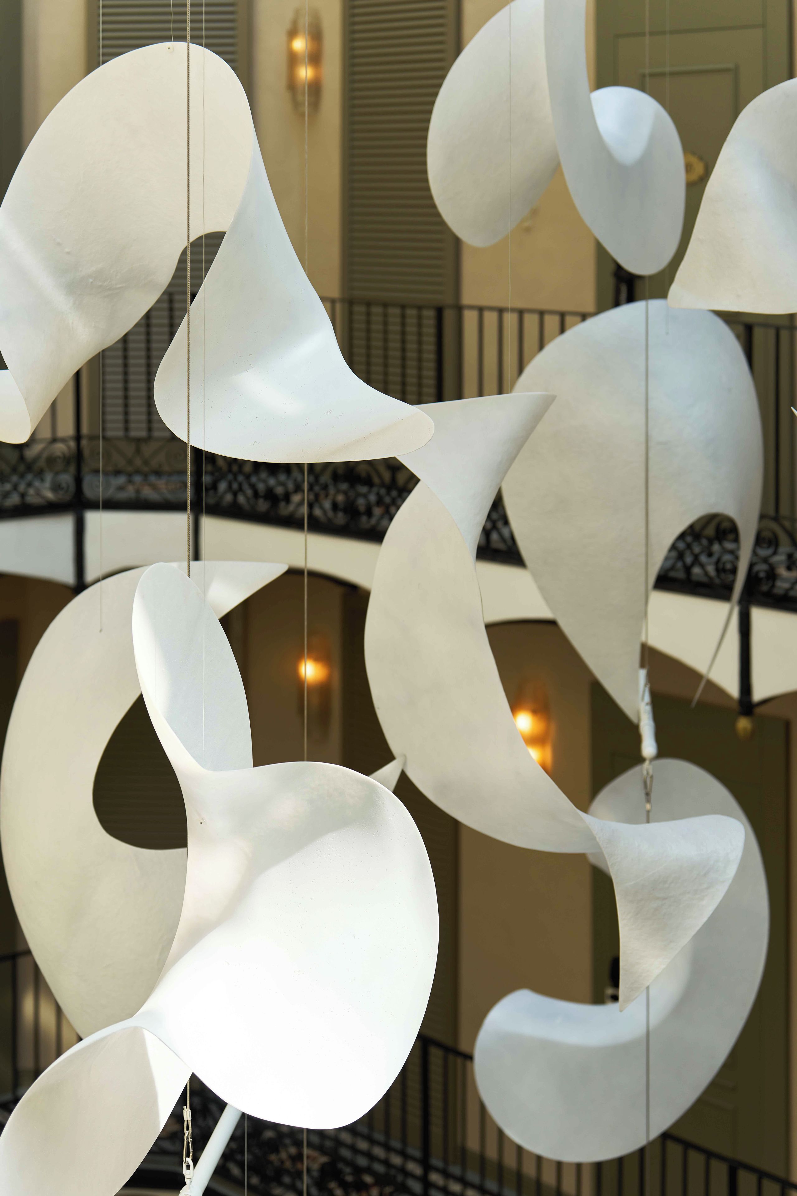 A modern interior with abstract white sculptures hanging from the ceiling.