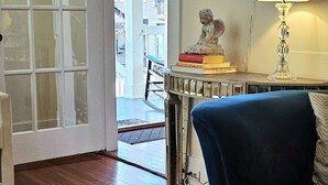 A room with a glass table, a blue sofa, a lamp, and a neon sign that reads "Oasis". - UPTOWN OASIS W PRIVATE, HEATED POOL, Minutes to all New Orleans' top attractions (New Orleans)