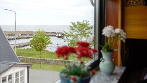 A view of a harbor with boats, a stone wall, and a grassy area. - Branteviks Bed & Breakfast (Brantevik)