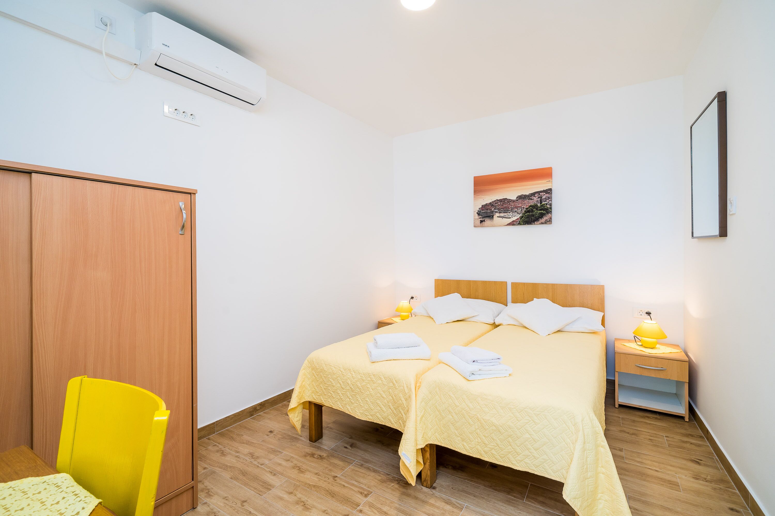 Una habitación de hotel con cama, mesita de noche, lámpara y una silla.