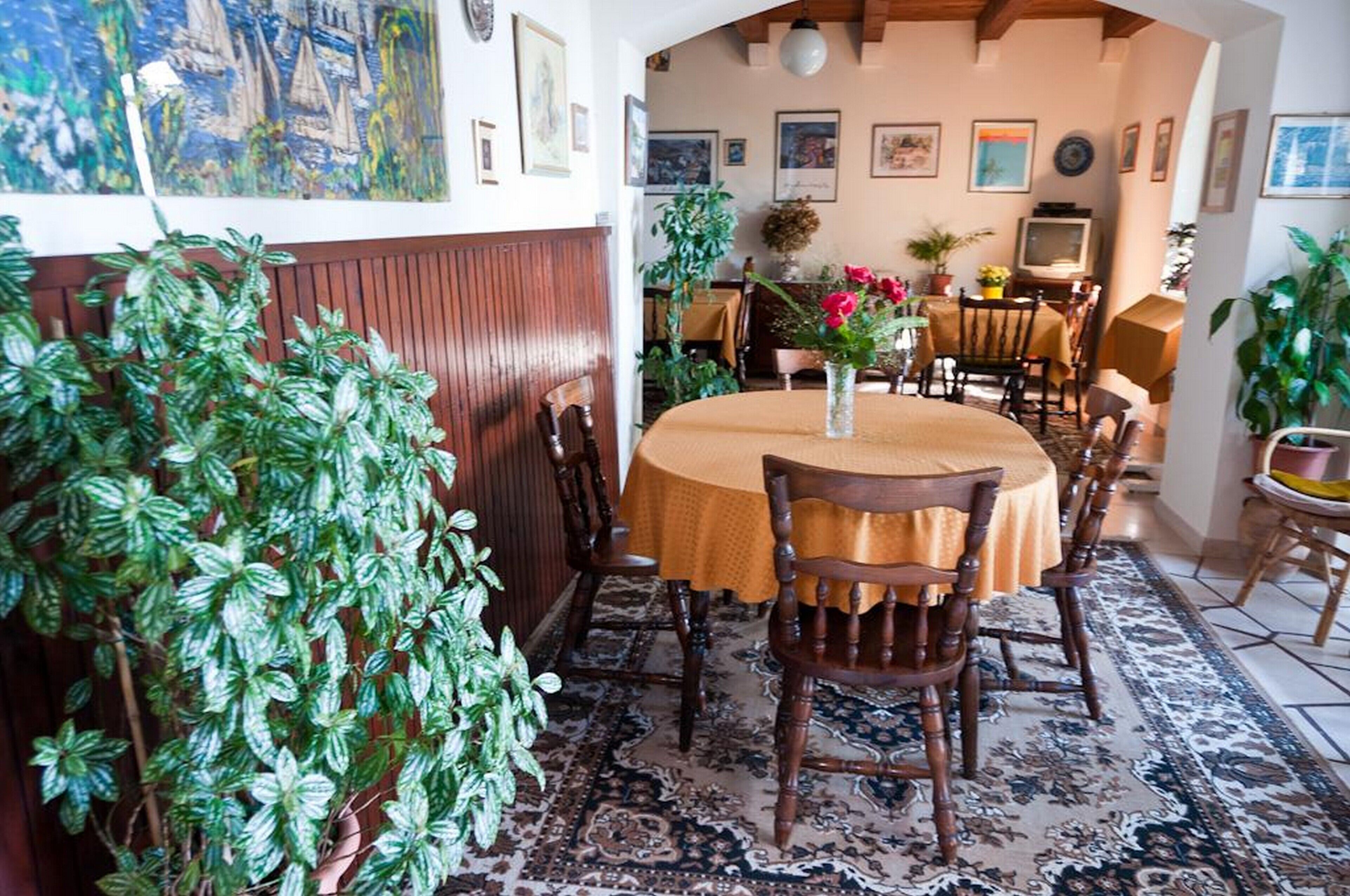 A dining area with a round table, wooden chairs, and a patterned rug.