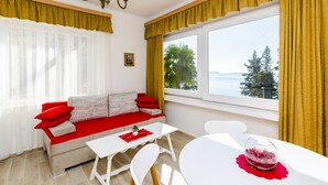 Un salon moderne avec un canapé, une petite table et une vue sur la mer.
