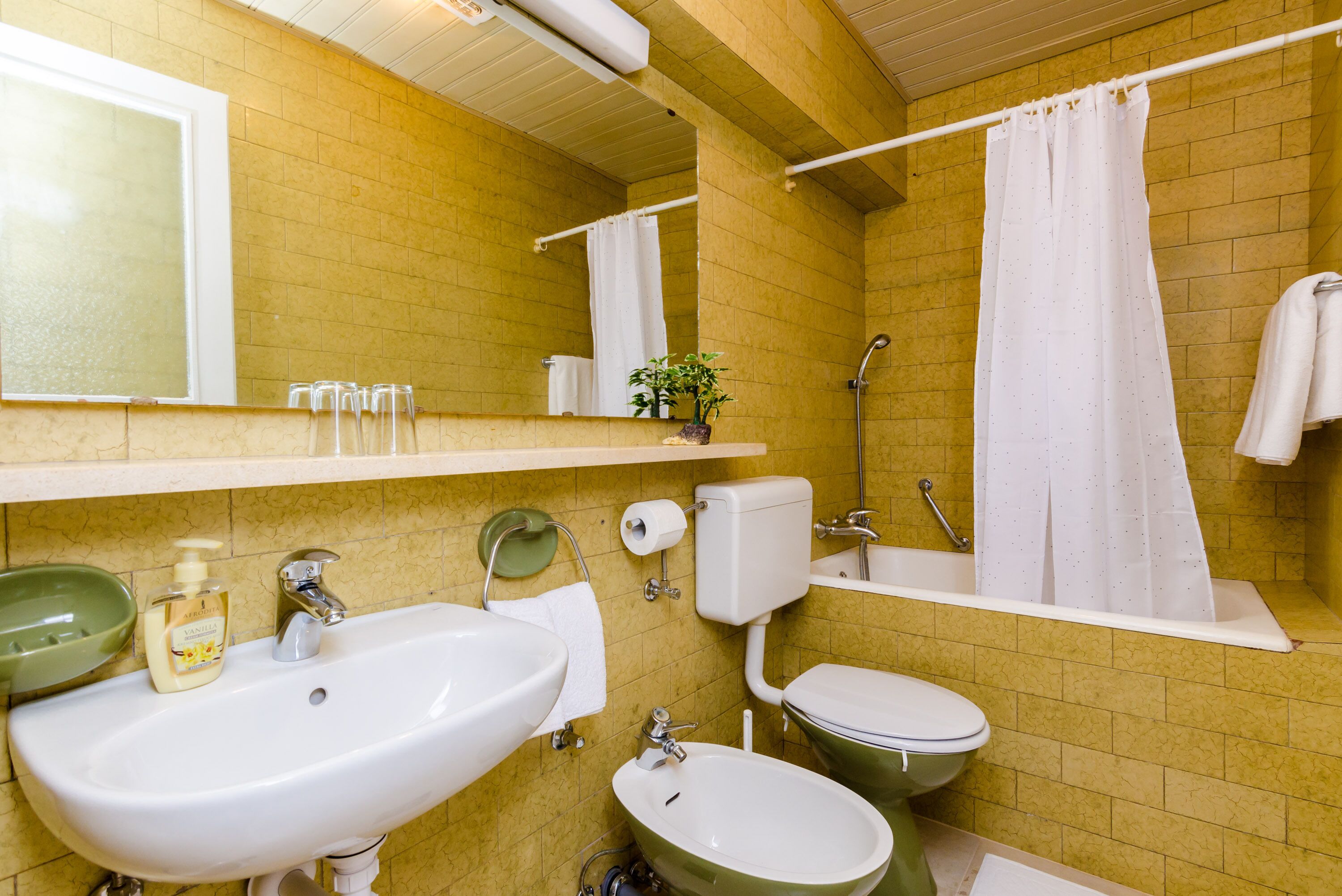 Een badkamer met een wastafel, toilet en bad.