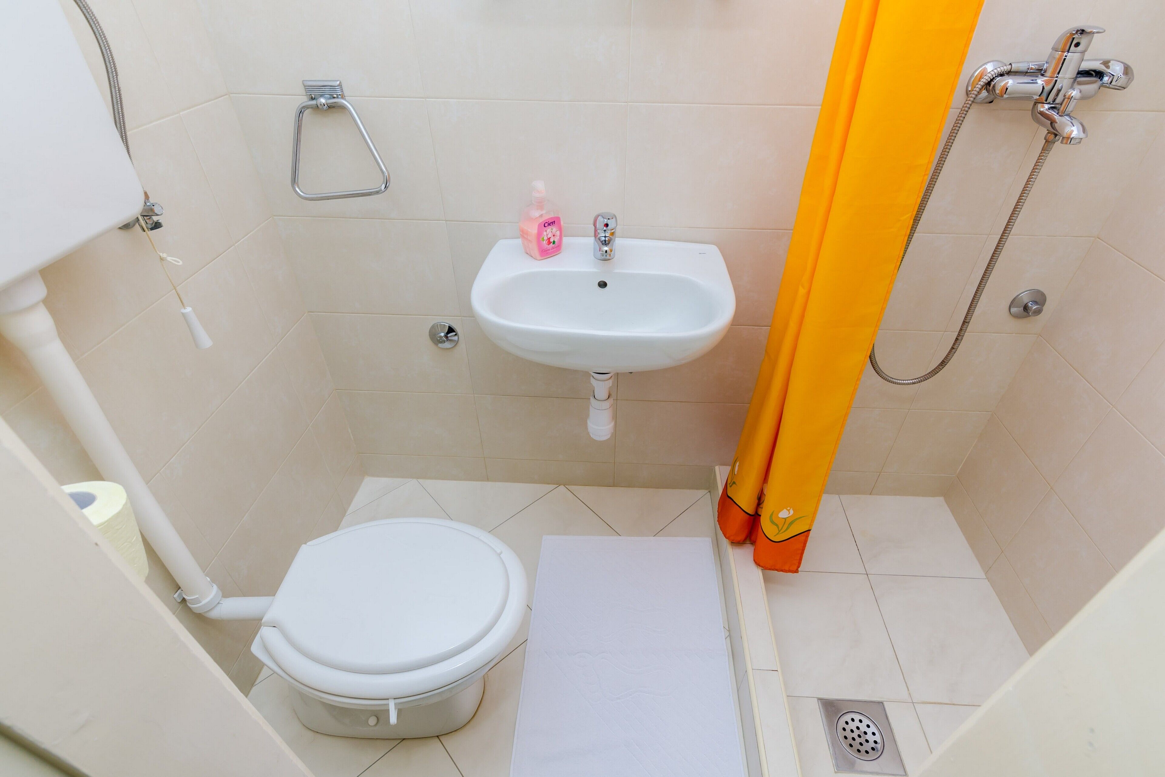 Une petite salle de bain avec des toilettes, un lavabo et une douche.