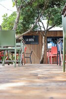 Un restaurante llamado 'LA BAINE' con terraza y fachada de madera.