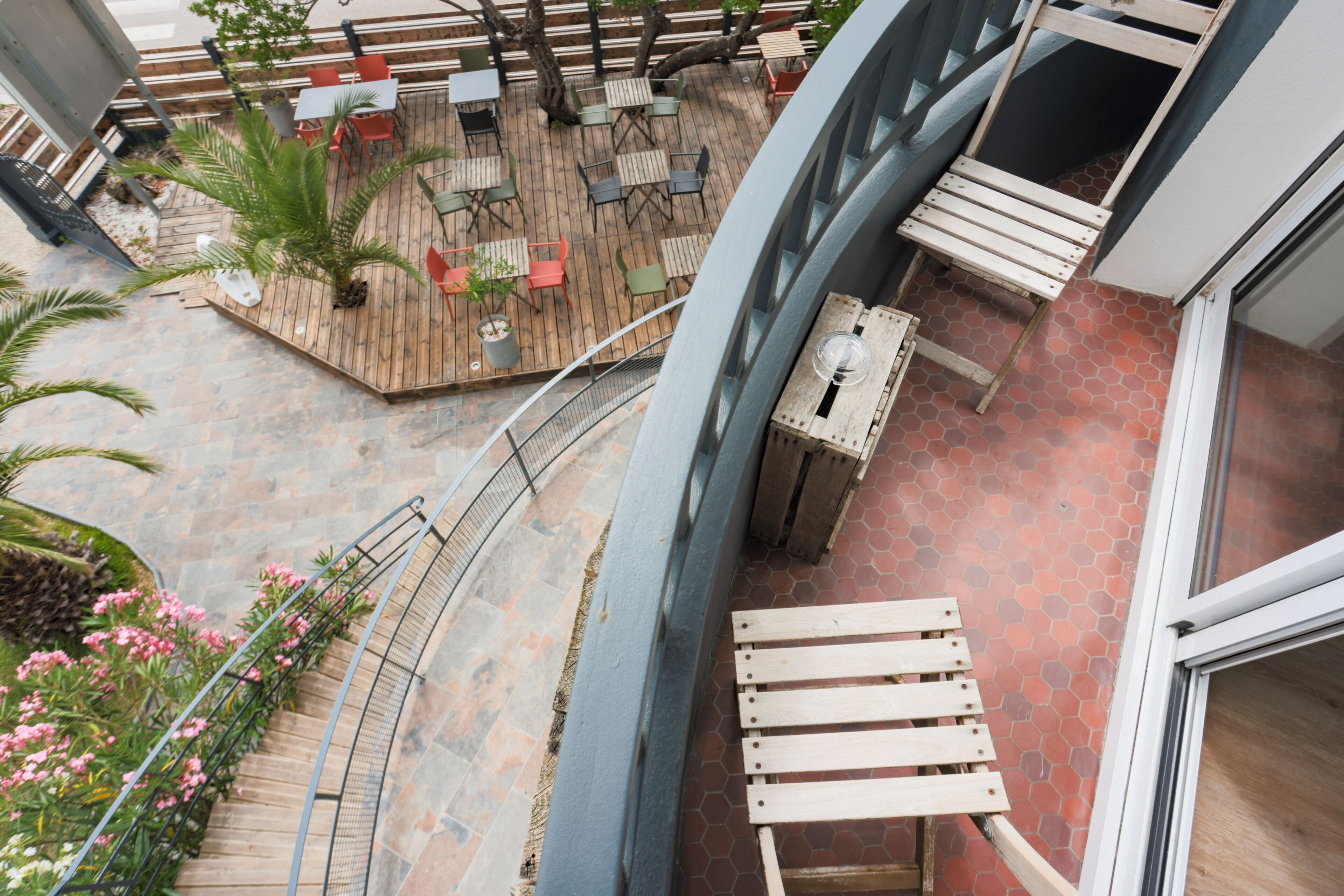A rooftop patio with outdoor seating, a staircase, and a view of the surrounding area.