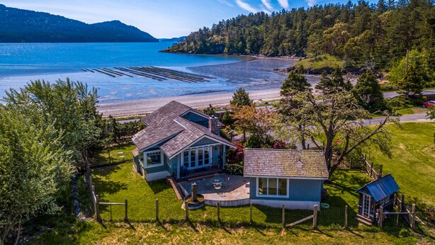 Una casa con patio, una pequeña terraza y vista al lago.