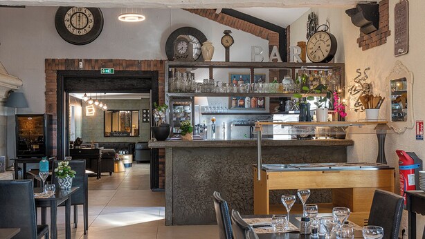 L’intérieur d’un restaurant, avec un bar, des tables et une variété d’objets décoratifs.