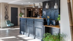 Une cuisine moderne avec des meubles de couleur bleu foncé, des luminaires suspendus et un plan de travail en bois.