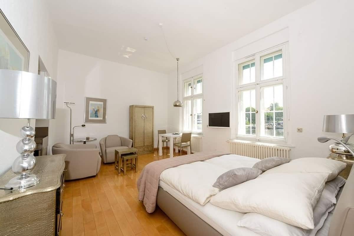 Une chambre spacieuse avec un grand lit, un bureau, une chaise et une armoire.