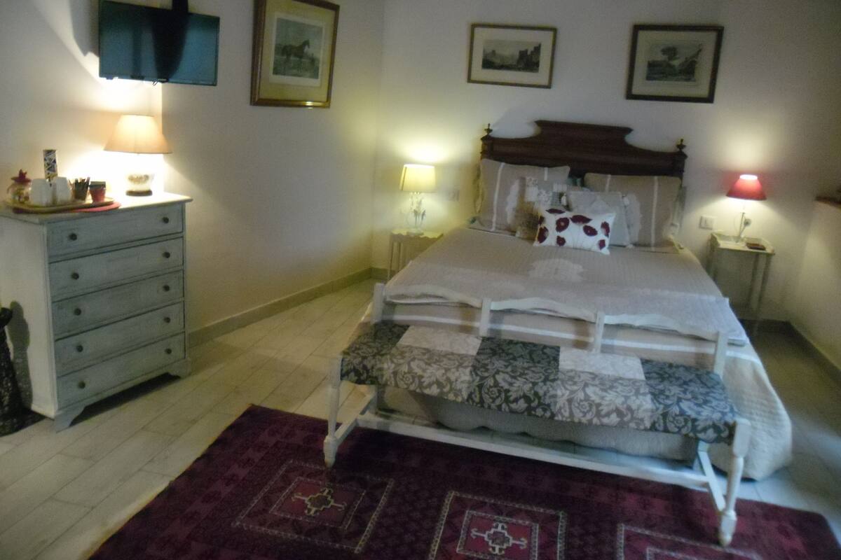 Une chambre à coucher avec un lit, une commode et une table de chevet.