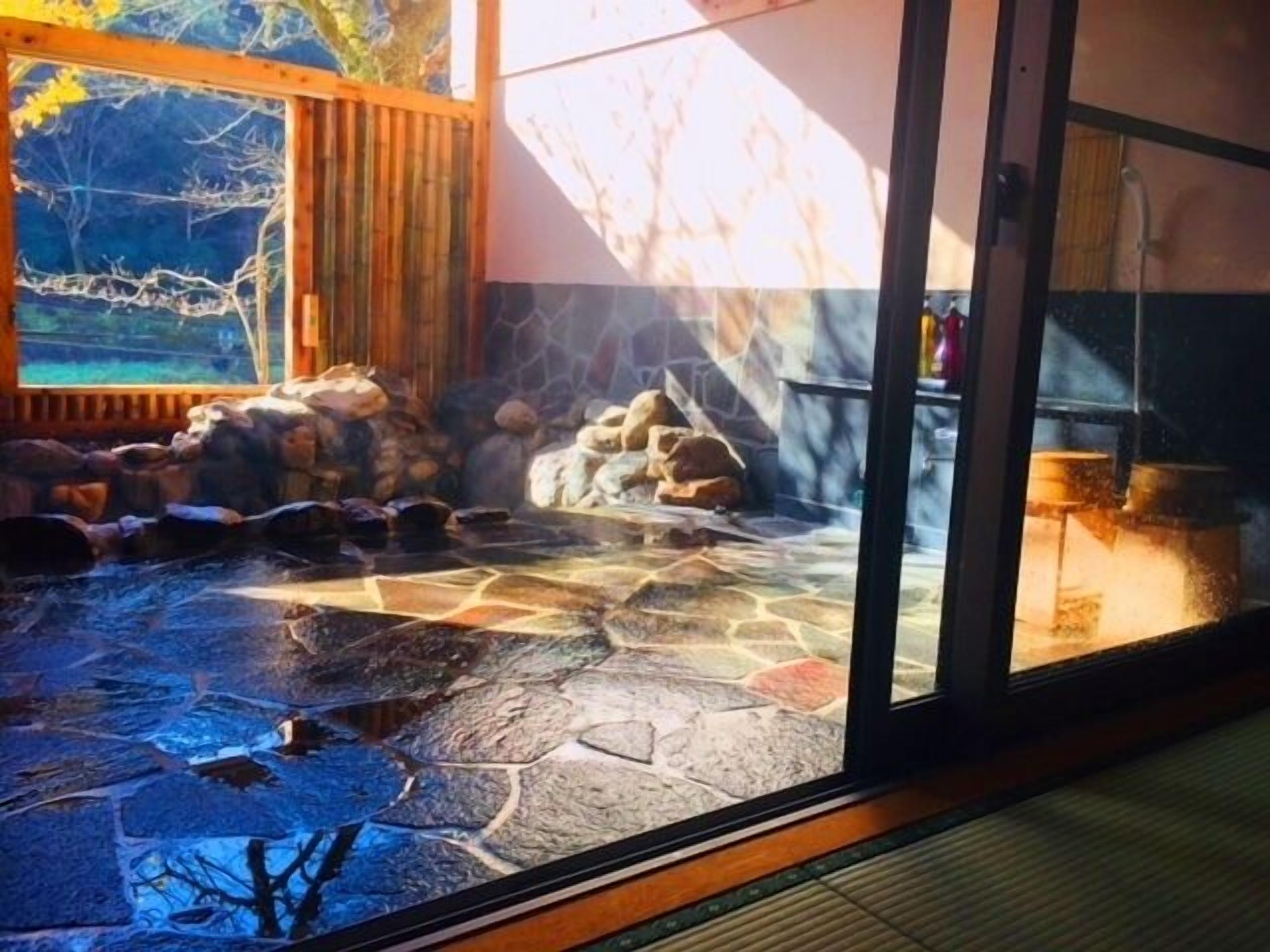 A stone-tiled patio with a rock arrangement and a wooden fence.
