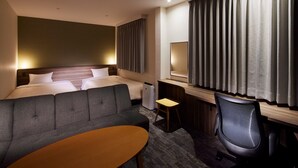 Een hotelkamer met een bed, een bank, een bureau en een stoel.