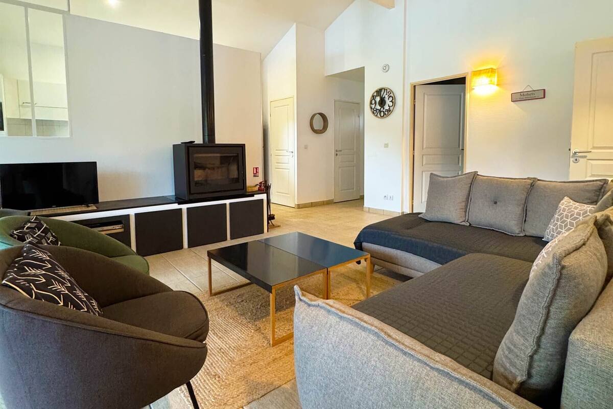 Una sala de estar con sofá, mesa de centro, televisión y chimenea.