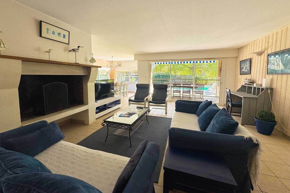 Una sala de estar con chimenea, televisor y zona de estar.