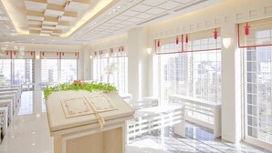 A bright, spacious hotel lobby with a modern design, featuring a central reception desk, large windows with decorative red lanterns, and a tiled floor. - International Hotel Ube (Ube)
