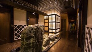 A corridor with wooden flooring, a rock garden, and traditional Japanese-style lanterns. - International Hotel Ube (Ube)