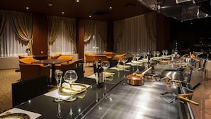 A restaurant with a long dining table set for a meal, featuring a variety of tableware and glassware. - International Hotel Ube (Ube)