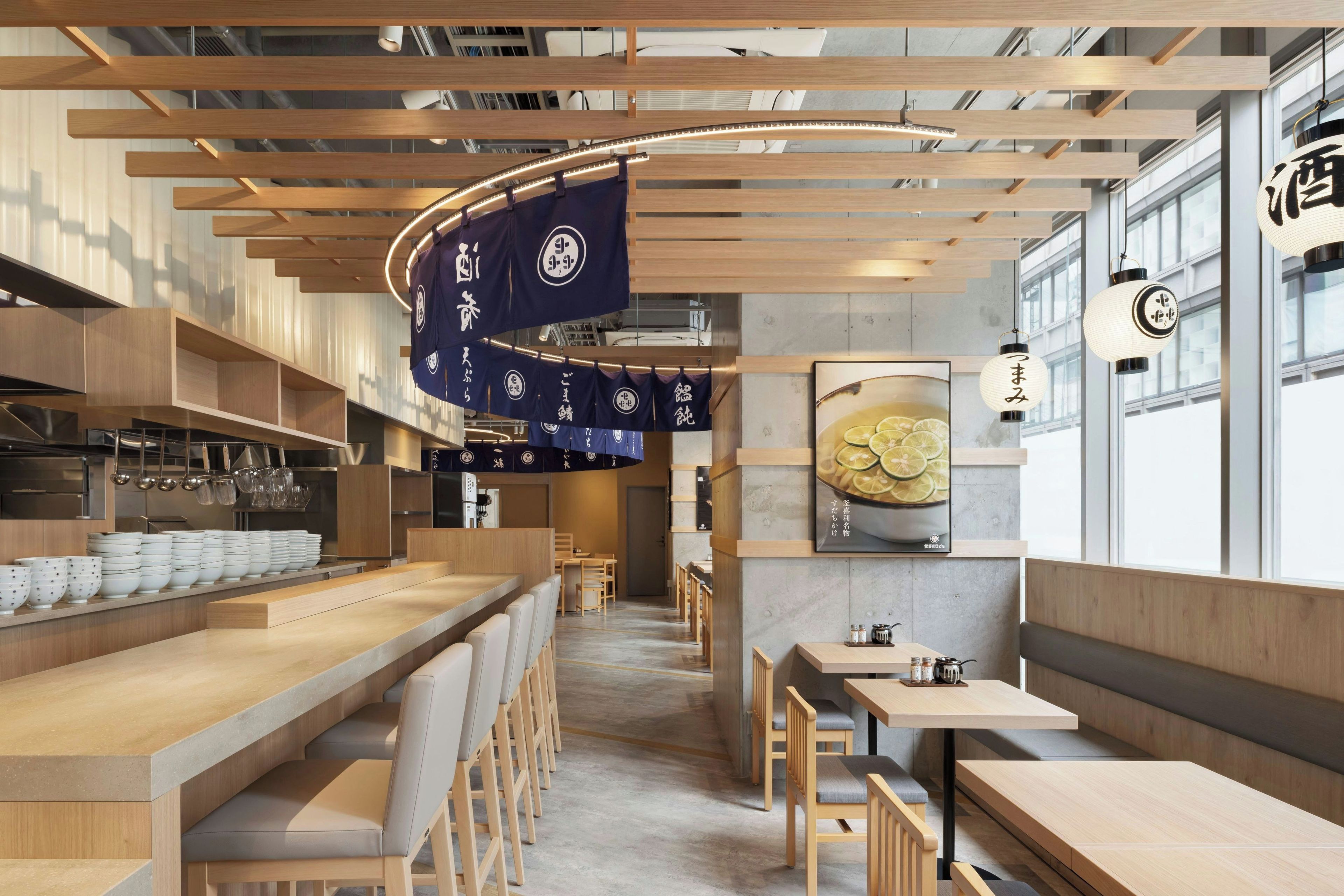 A restaurant interior with wooden furniture, hanging flags, and a large window.