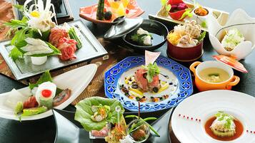 Una variedad de platos en una mesa, incluyendo sushi, sashimi y otras entradas.