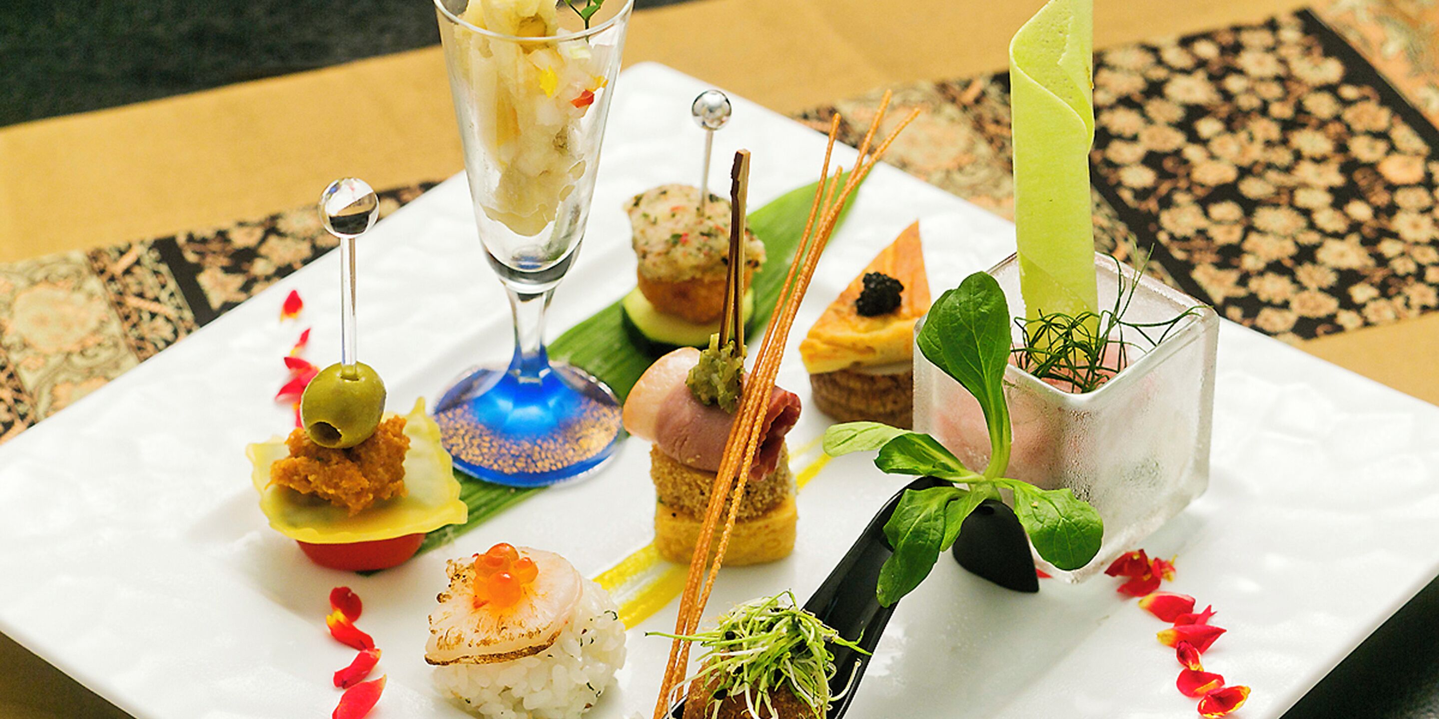 A variety of appetizers arranged on a white square plate.