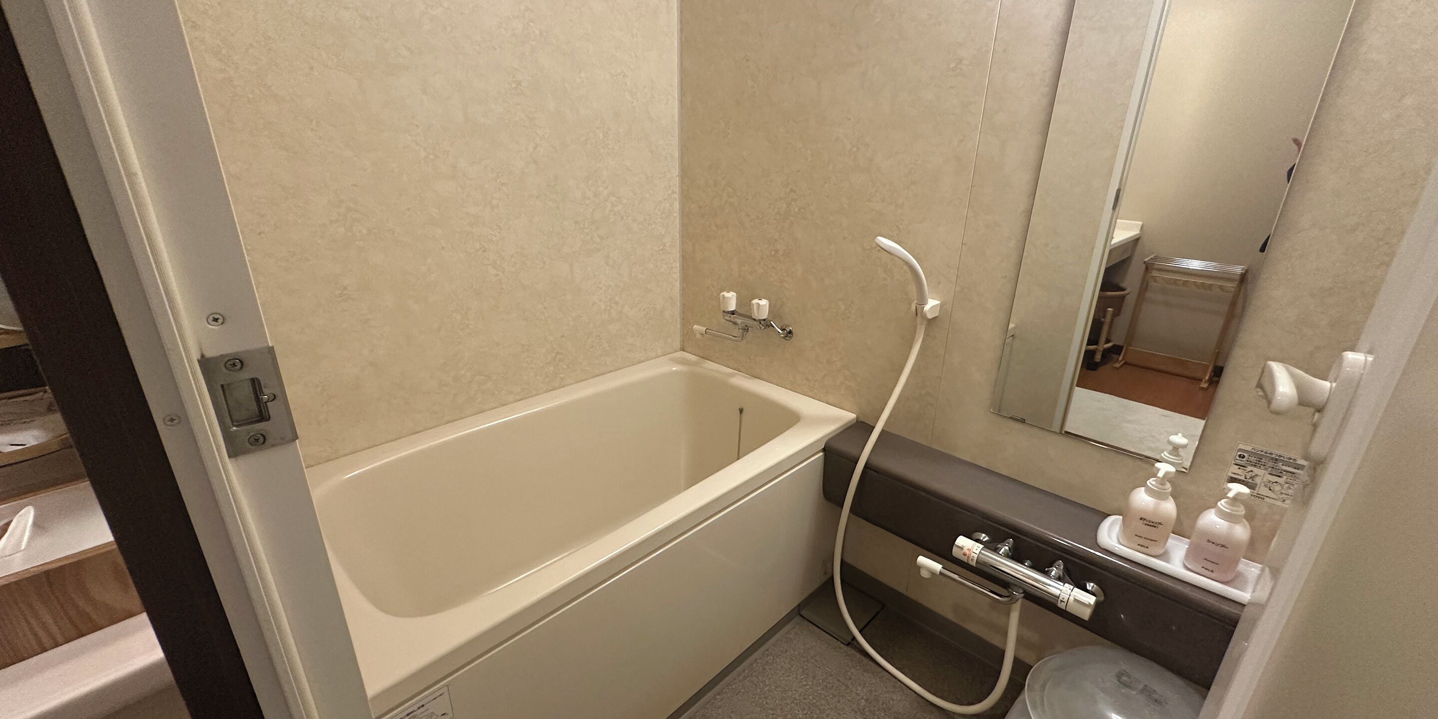 A bathroom with a bathtub, a sink, and a mirror.