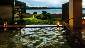 Een warmwaterbronnenlandschap met uitzicht op een meer en bergen.