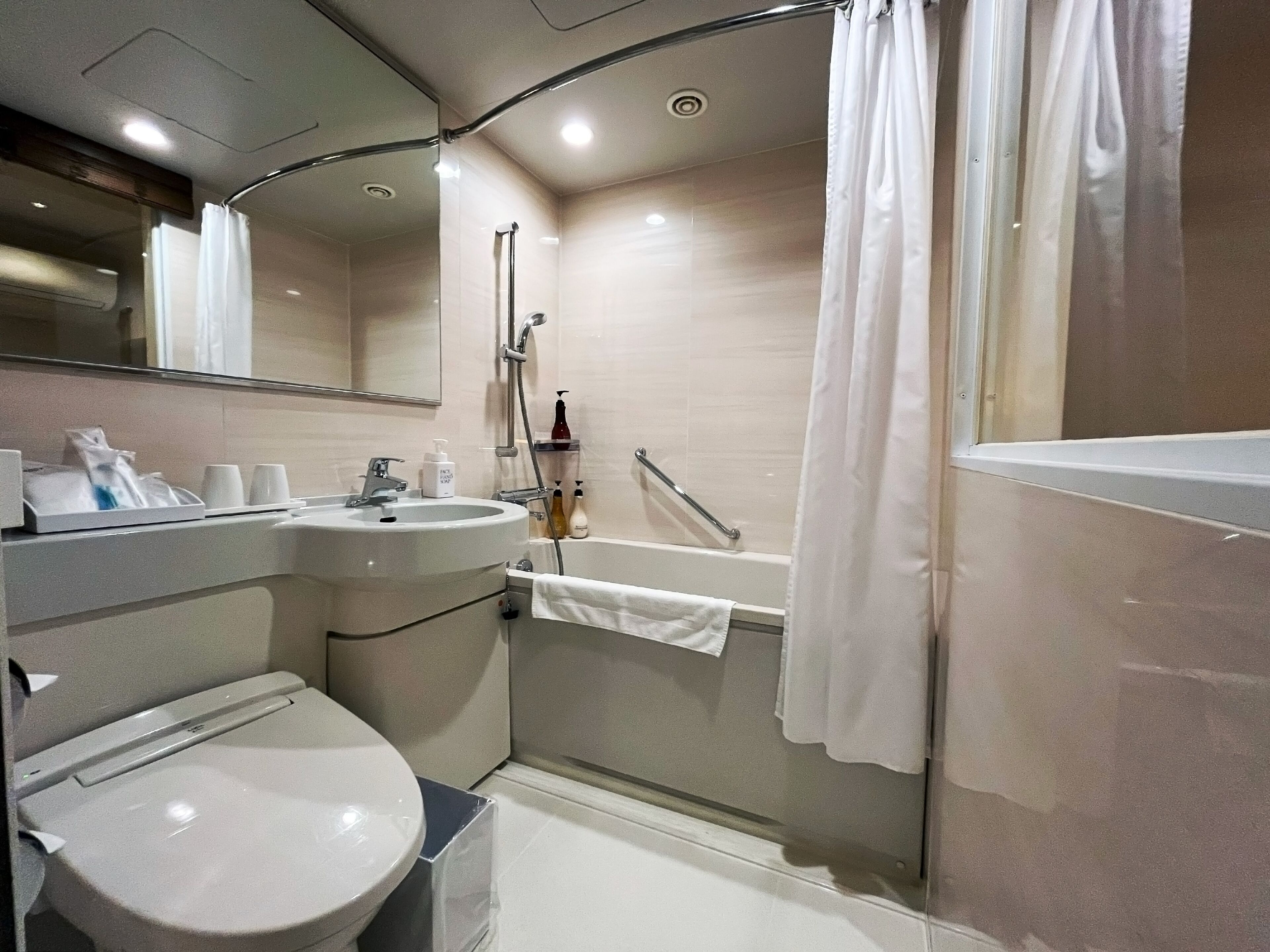 A modern bathroom with a sink, toilet, and bathtub.