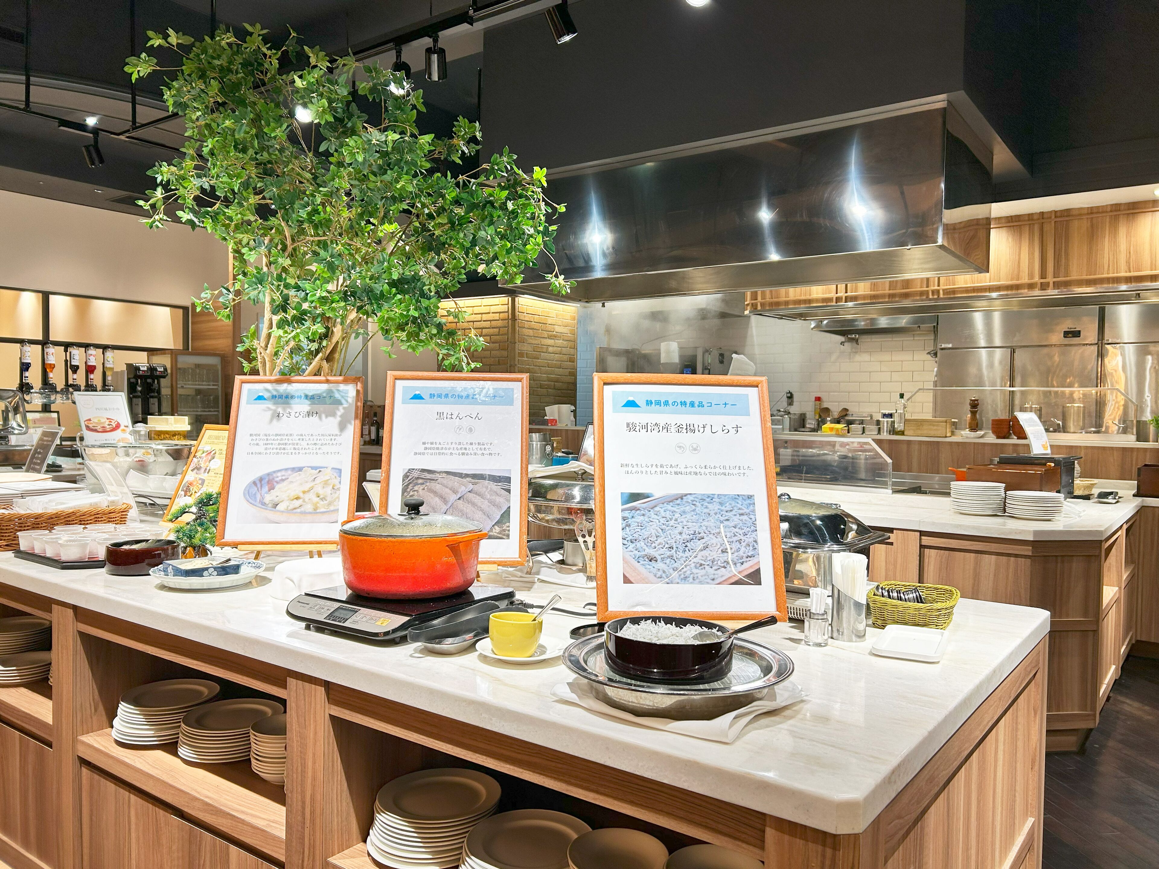 A buffet setup with various dishes, a weighing scale, and informational signs.