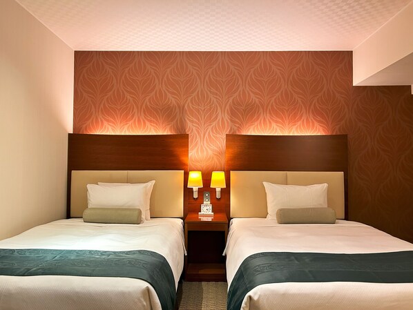 A hotel room with two beds, a wooden headboard, a patterned wallpaper, and two bedside lamps.