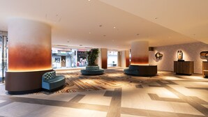 A spacious lobby with large cylindrical columns, seating areas, and a patterned carpet. - Nakajimaya Grand Hotel (Shizuoka)