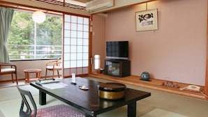A traditional Japanese-style room with tatami flooring, a low table, and a television. - Gyokusenkaku (Nagato)